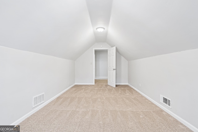 bonus room featuring light carpet and vaulted ceiling