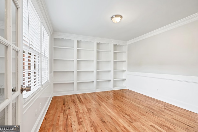 empty room featuring hardwood / wood-style flooring and crown molding