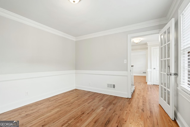 empty room featuring light hardwood / wood-style flooring and crown molding