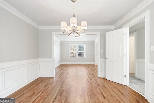 unfurnished dining area with ornamental molding, light hardwood / wood-style flooring, and a notable chandelier