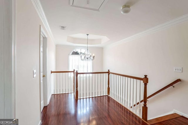 hall featuring an inviting chandelier, dark hardwood / wood-style floors, and ornamental molding