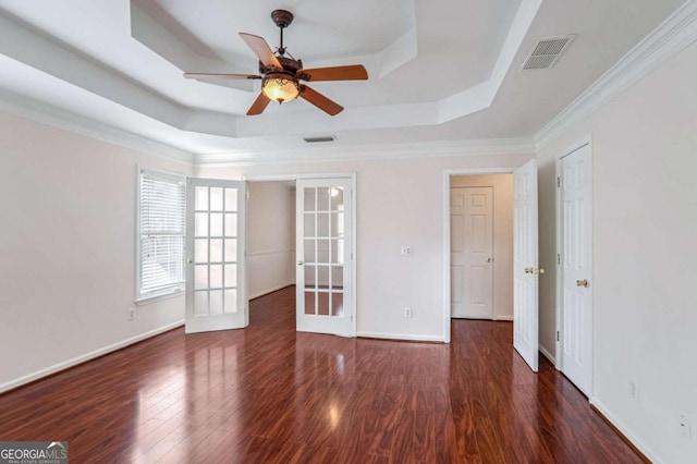 unfurnished room with dark wood-type flooring, french doors, ceiling fan, ornamental molding, and a tray ceiling