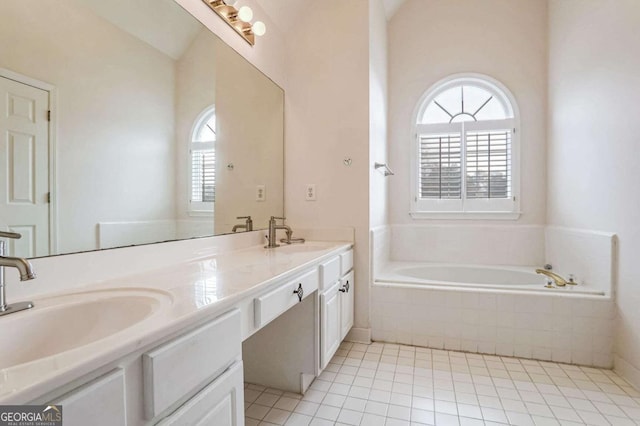 bathroom with tiled tub, tile patterned flooring, and vanity