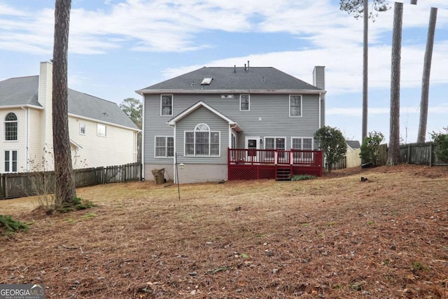 back of house with a lawn and a deck