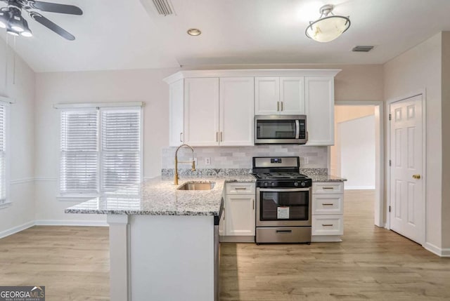 kitchen with white cabinets, light wood-type flooring, sink, and appliances with stainless steel finishes