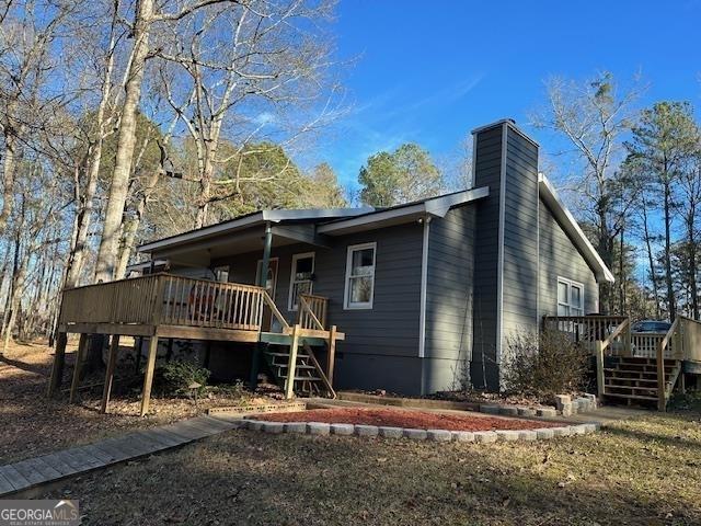 2020 Moore Rd, Moreland, GA 30259 - view of front of home featuring central air condition unit, a wooden deck, a chimney, and metal roof