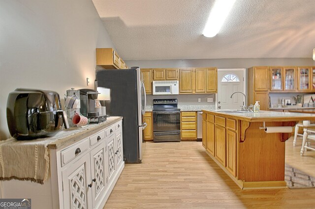 2020 Moore Rd, Moreland, GA 30259 - kitchen featuring an island with sink, a kitchen bar, light countertops, a sink, and appliances with stainless steel finishes