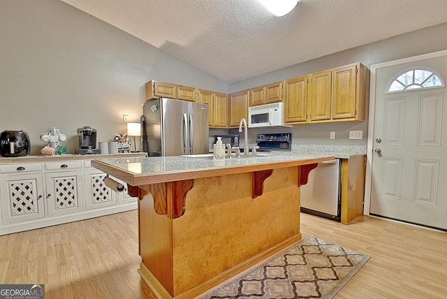 2020 Moore Rd, Moreland, GA 30259 - kitchen featuring stainless steel appliances, light wood finished floors, lofted ceiling, a kitchen bar, and a kitchen island