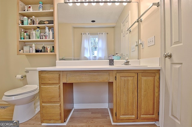 bathroom featuring vanity, hardwood / wood-style flooring, and toilet