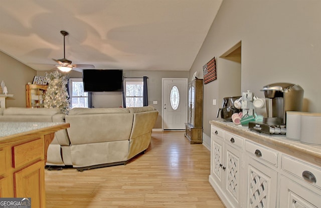 living room with light hardwood / wood-style flooring, ceiling fan, and lofted ceiling