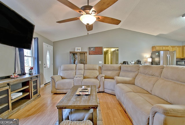 living room with ceiling fan, light hardwood / wood-style flooring, and lofted ceiling