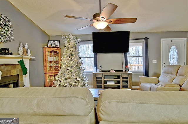 living room with a fireplace, vaulted ceiling, plenty of natural light, and ceiling fan