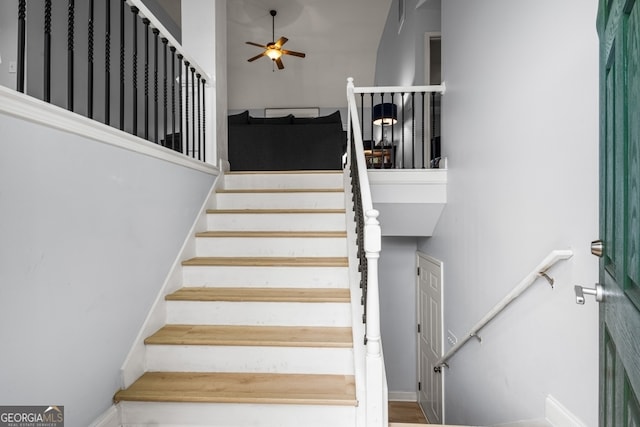 staircase featuring ceiling fan