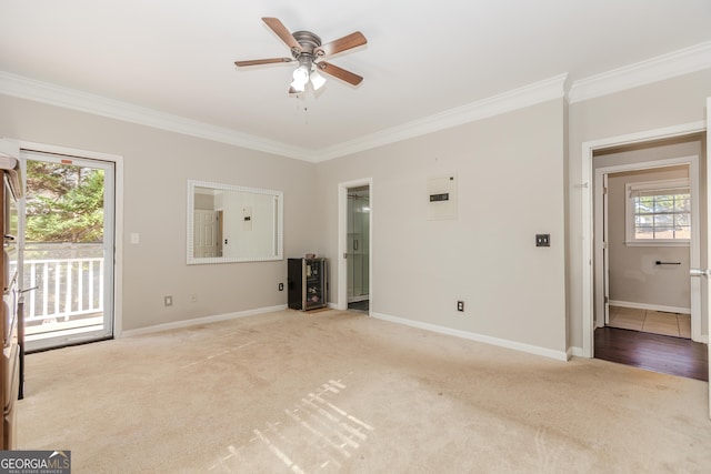 empty room with ceiling fan, electric panel, crown molding, and light carpet