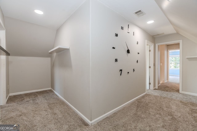 hallway featuring lofted ceiling, recessed lighting, light colored carpet, visible vents, and baseboards