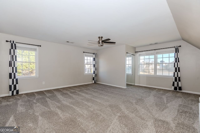 spare room featuring a wealth of natural light, ceiling fan, carpet floors, and lofted ceiling