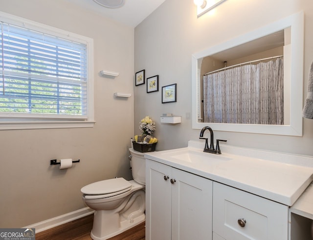 bathroom featuring baseboards, vanity, toilet, and wood finished floors