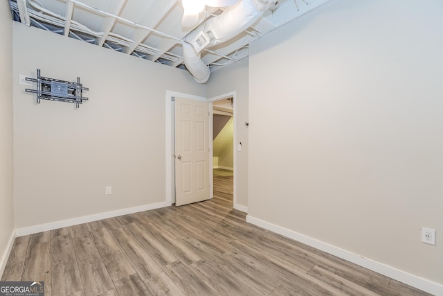 spare room featuring baseboards and wood finished floors