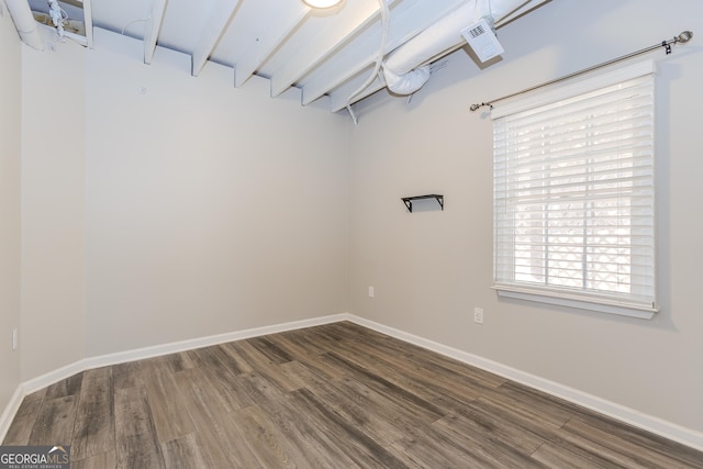 unfurnished room featuring dark wood-style flooring and baseboards