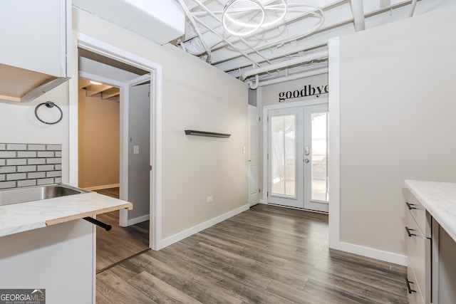 interior space featuring dark wood-type flooring, french doors, and baseboards