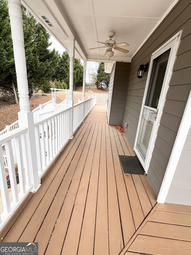 entrance to property with ceiling fan and a porch