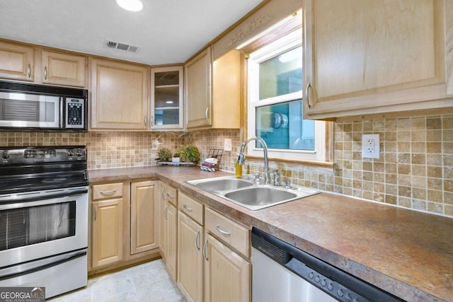 kitchen with decorative backsplash, light brown cabinets, stainless steel appliances, and sink