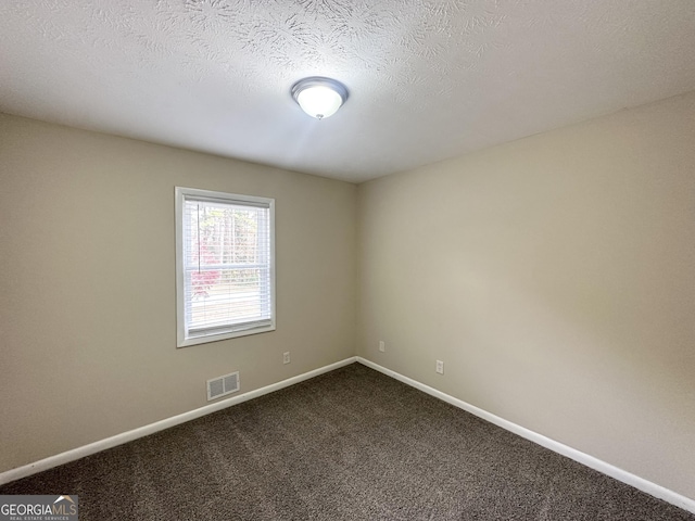 carpeted empty room featuring a textured ceiling