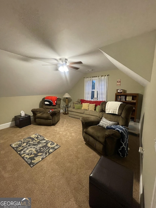 living room with ceiling fan, carpet floors, and vaulted ceiling