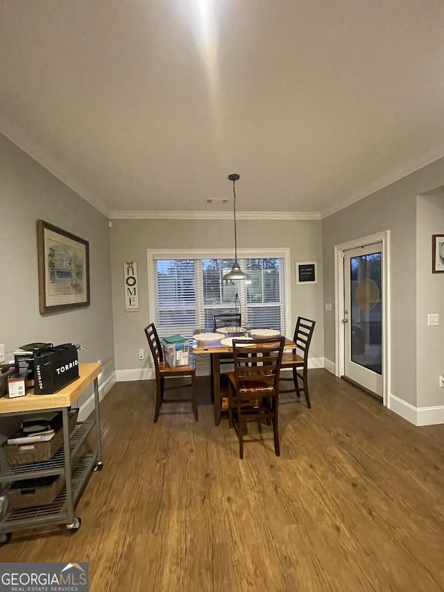 dining room featuring dark hardwood / wood-style flooring and ornamental molding