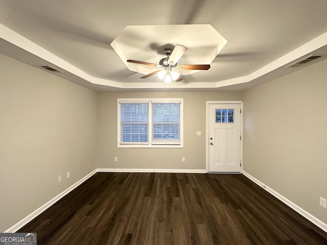 entryway with dark hardwood / wood-style floors, a raised ceiling, and ceiling fan