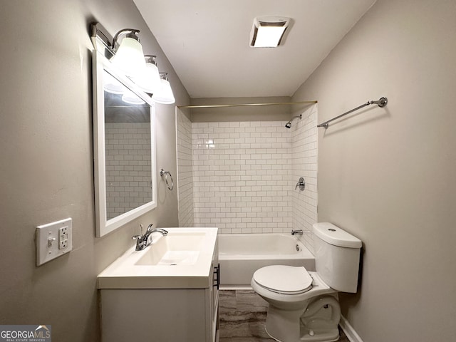 full bathroom featuring vanity, tiled shower / bath combo, and toilet