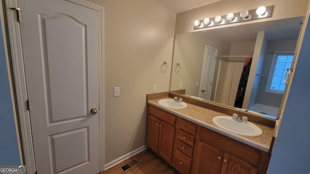 bathroom featuring hardwood / wood-style floors, vanity, and walk in shower