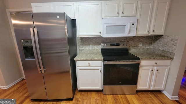 kitchen with white cabinets, stainless steel appliances, and light hardwood / wood-style floors