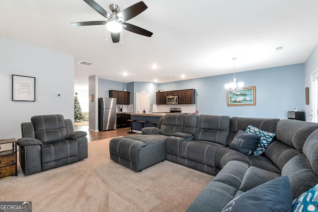 living room featuring recessed lighting, visible vents, and ceiling fan with notable chandelier