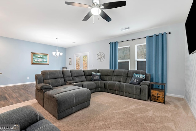 living area featuring visible vents, ceiling fan with notable chandelier, and baseboards