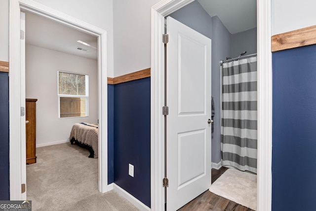 bathroom with a shower with shower curtain, visible vents, and baseboards