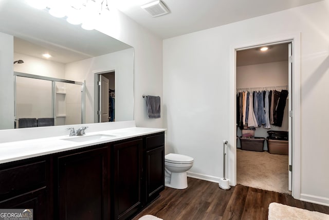 full bathroom featuring vanity, wood finished floors, visible vents, a stall shower, and toilet