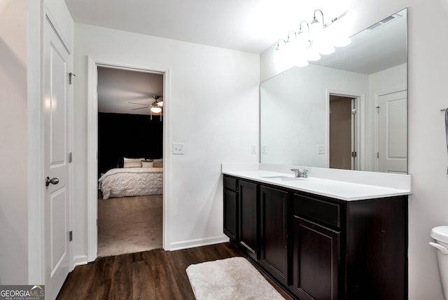 ensuite bathroom featuring visible vents, toilet, ensuite bath, wood finished floors, and vanity