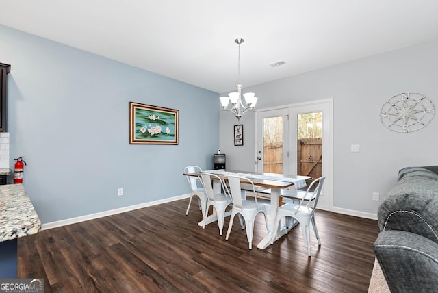 dining space with dark wood finished floors, an inviting chandelier, baseboards, and visible vents