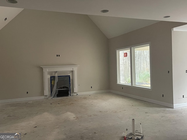 unfurnished living room with high vaulted ceiling