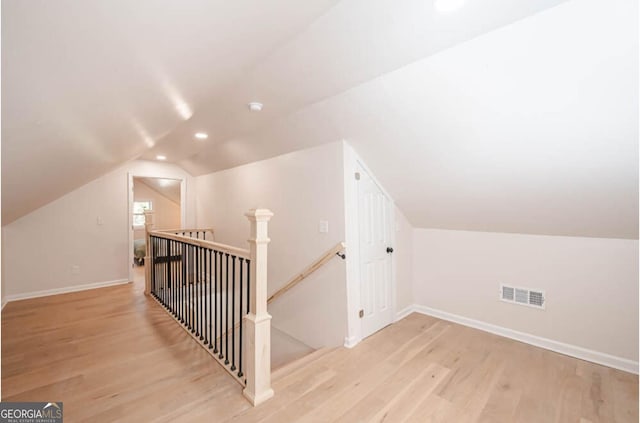 additional living space featuring lofted ceiling and light wood-type flooring