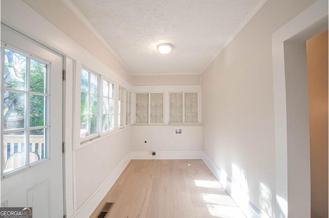 washroom with crown molding, light hardwood / wood-style flooring, a textured ceiling, and hookup for an electric dryer