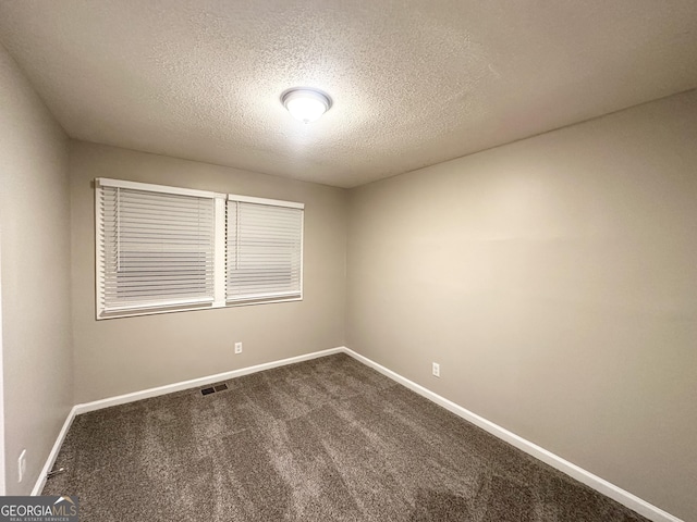 carpeted spare room with a textured ceiling