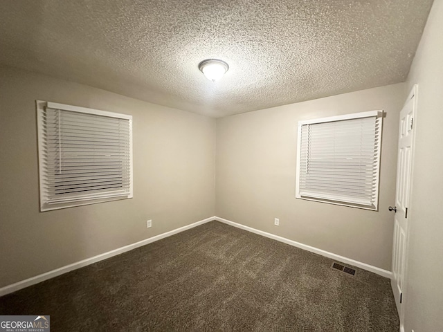 carpeted spare room with a textured ceiling