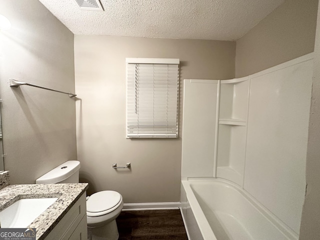 full bathroom featuring vanity, a textured ceiling, hardwood / wood-style flooring, and toilet