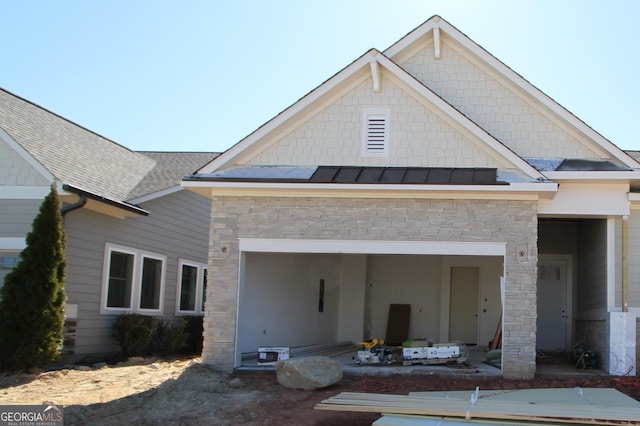 view of front facade featuring a garage, a standing seam roof, metal roof, and roof with shingles