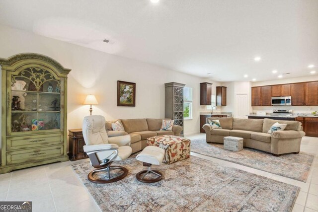 living room featuring light tile patterned floors and sink