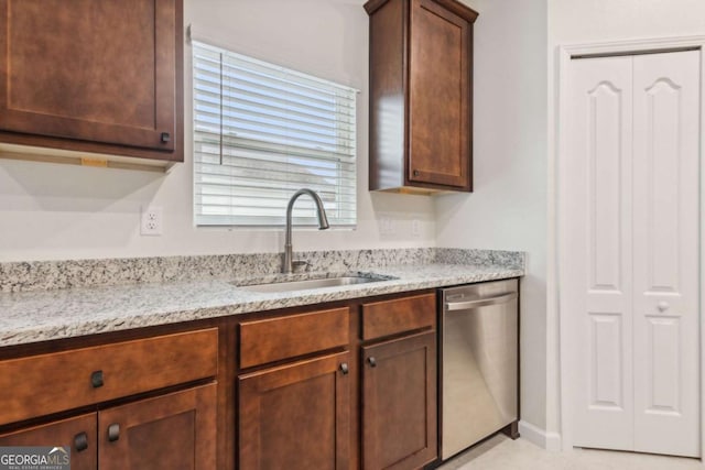 kitchen featuring dishwasher, light stone countertops, and sink