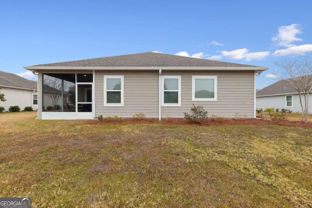 rear view of property with a sunroom and a lawn