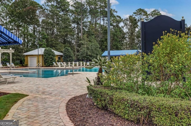 view of swimming pool featuring a patio and an outdoor structure